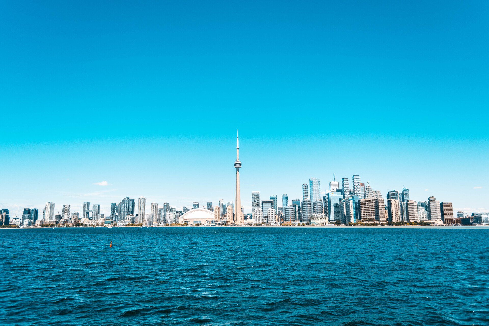 The skyline of toronto is visible from the water.