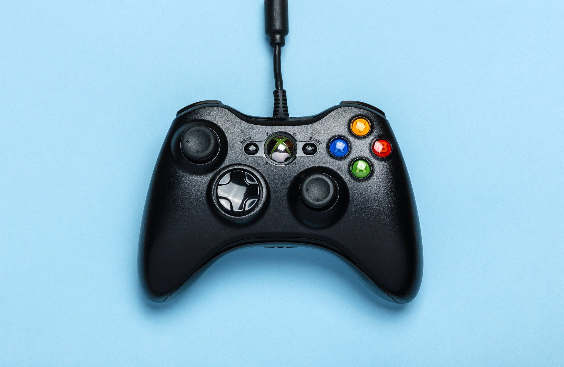 A close up of a video game controller on a blue background.