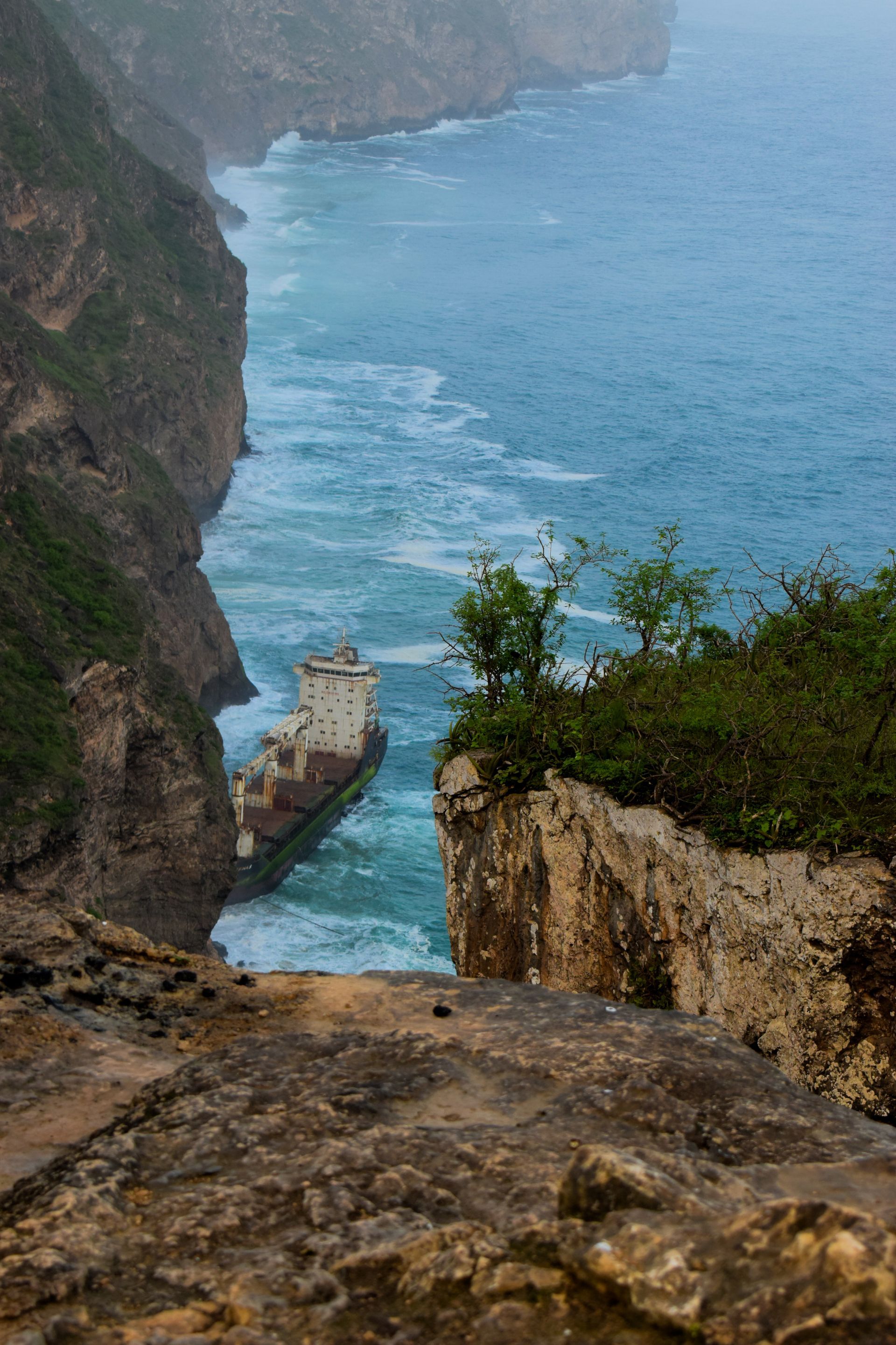 A view of the ocean from the top of a cliff.