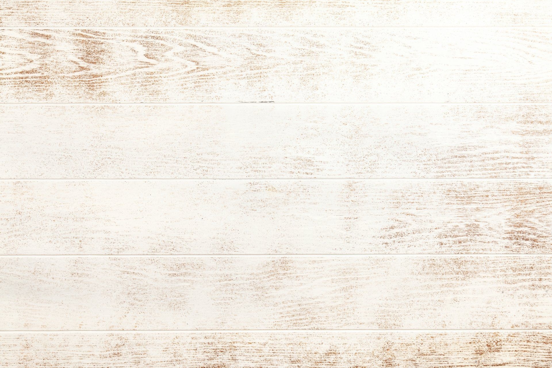 A close up of a white wooden wall with a brown stain on it.
