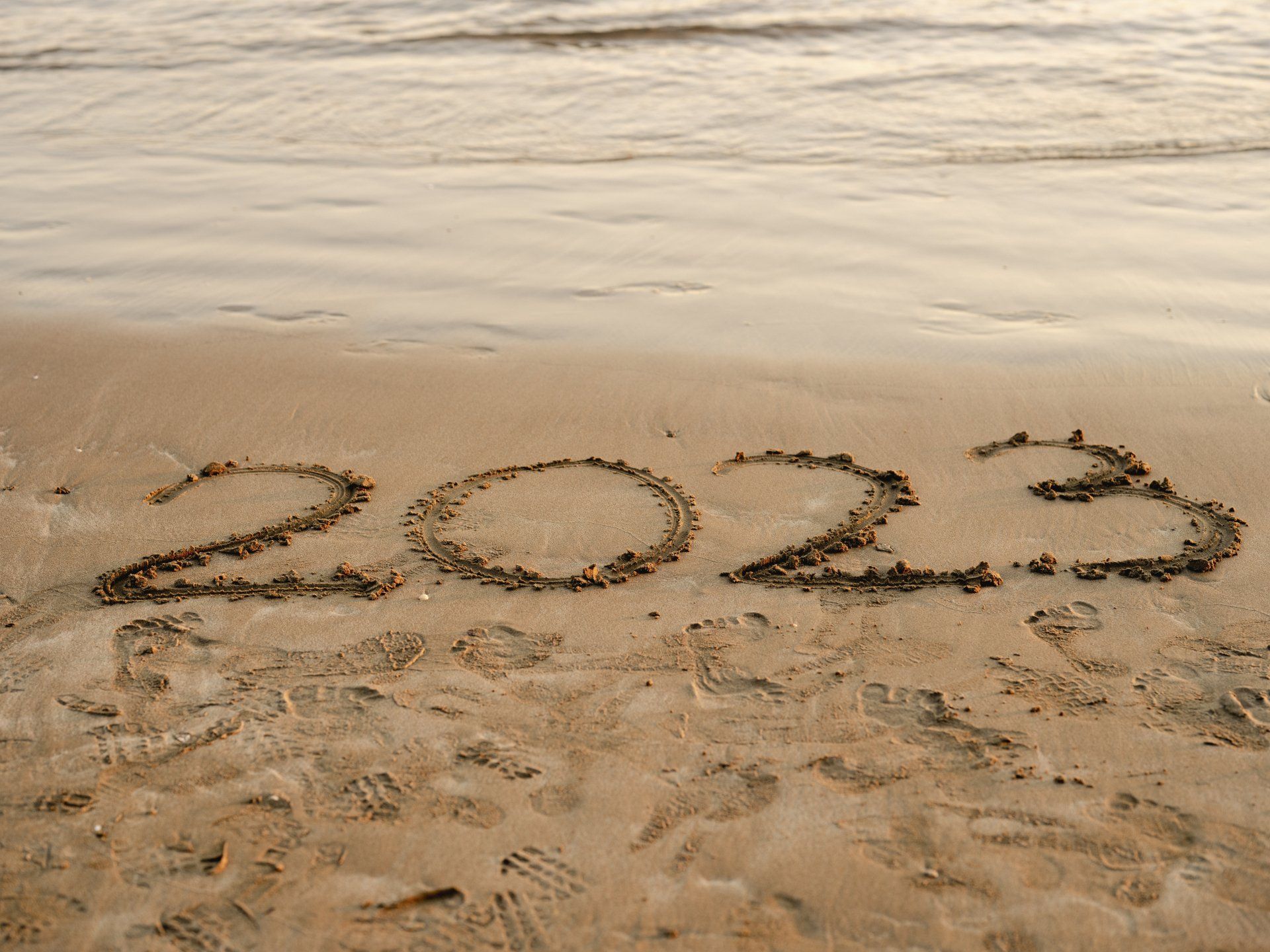 The numbers 2023 written in the sand