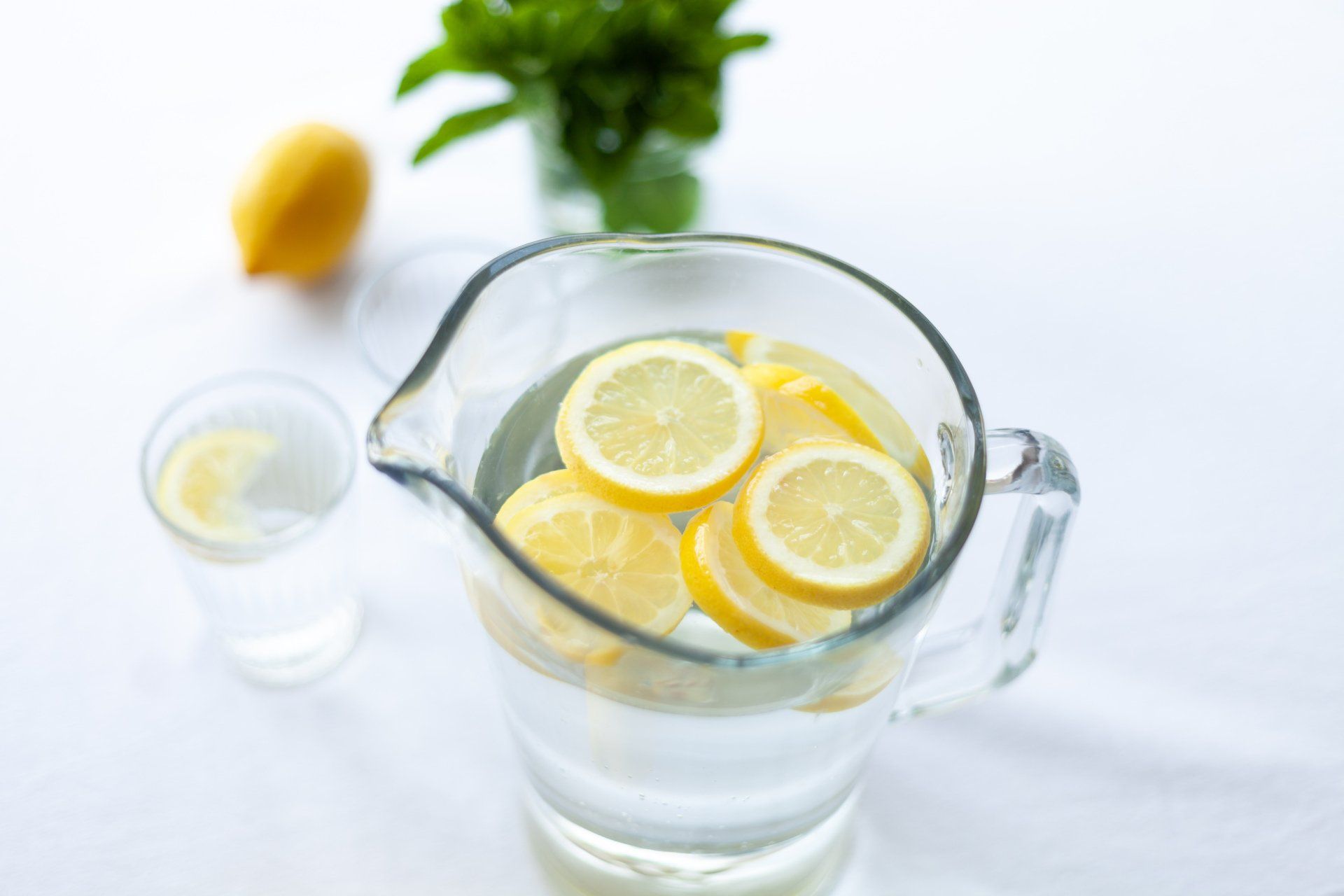 A pitcher of water with lemon slices in it.