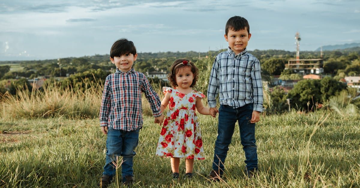 Three children standing in a field.