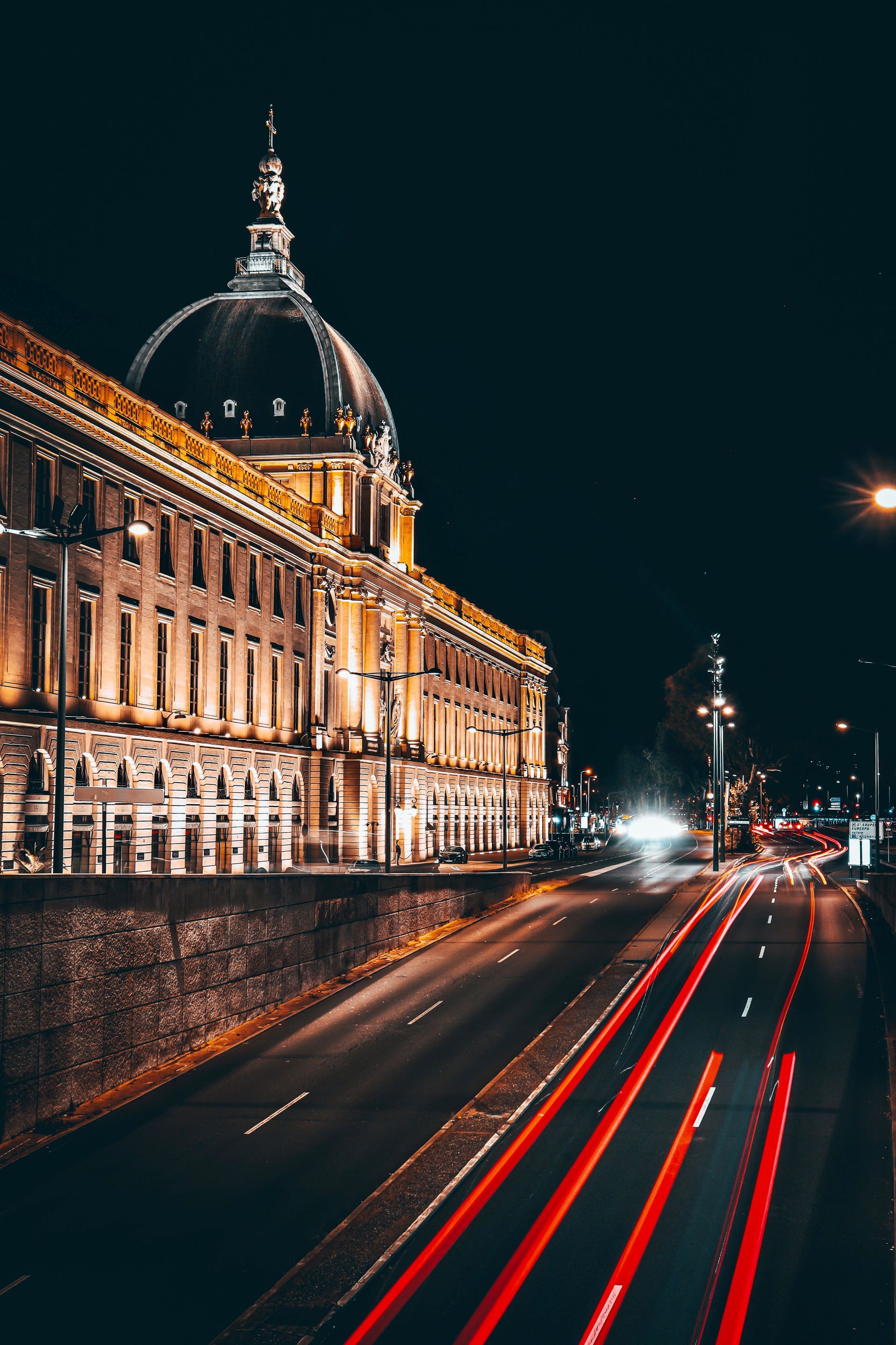 A large building with a dome on top of it is lit up at night.
