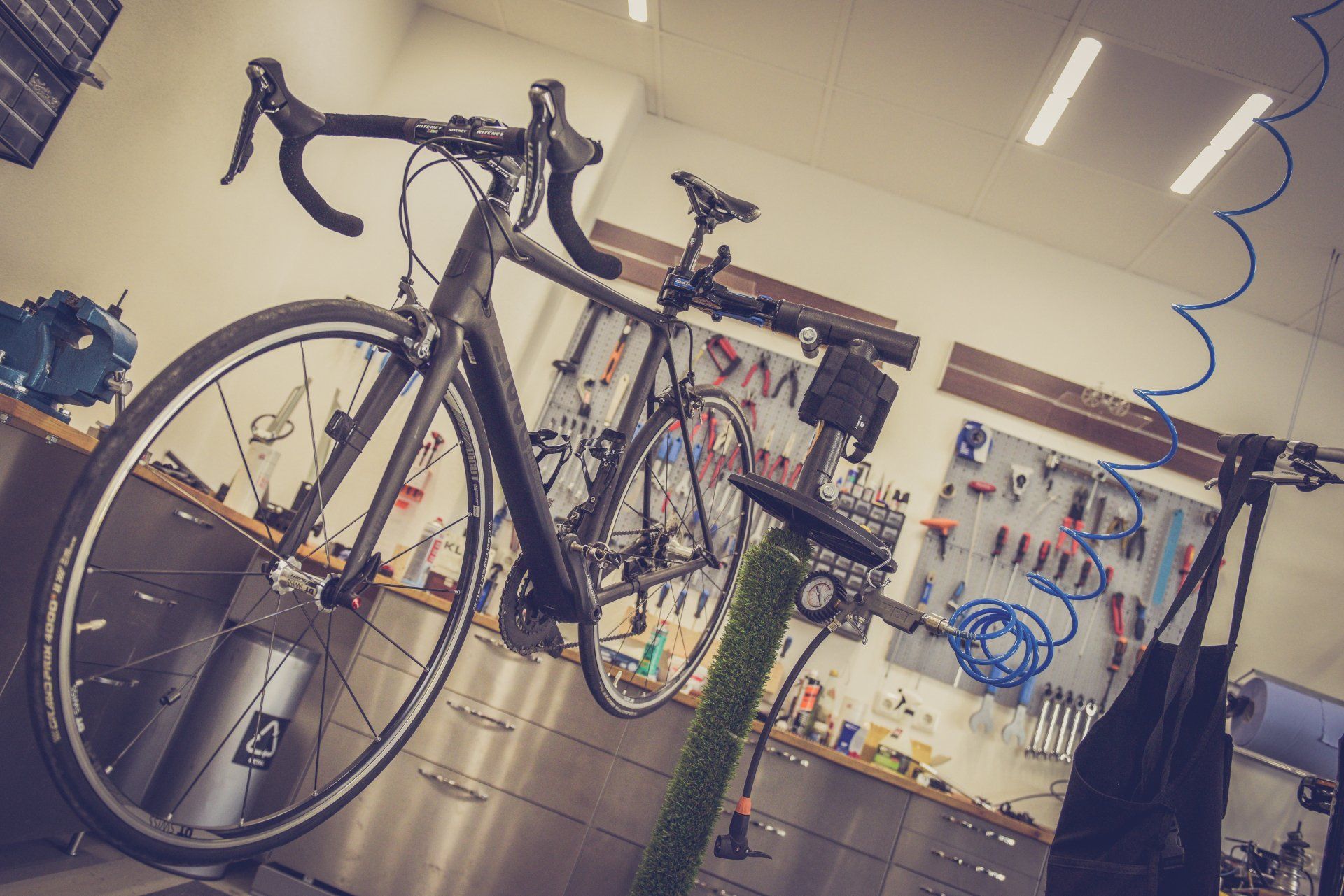 A bicycle is sitting on a stand in a garage.