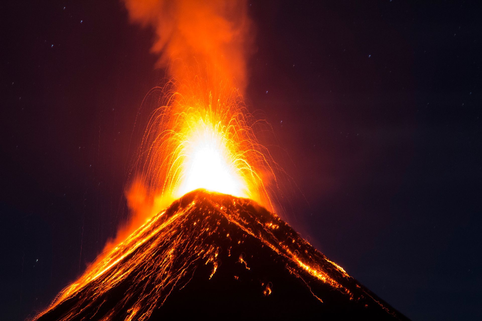 A volcano is erupting with a lot of smoke coming out of it