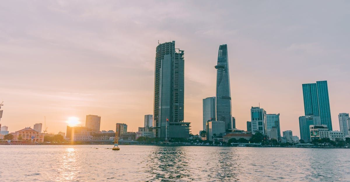 A city skyline overlooking a body of water at sunset.