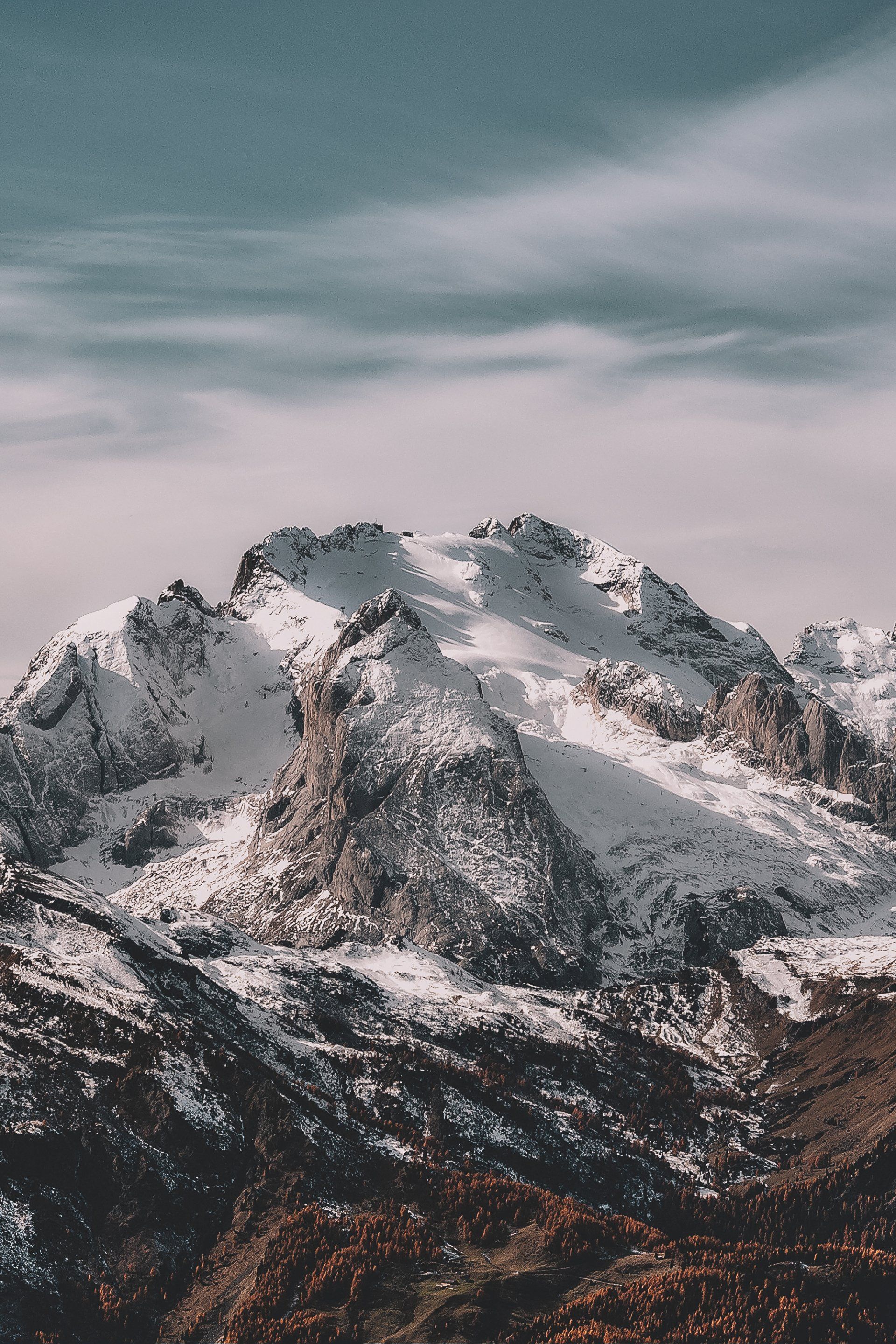 A snowy mountain with a blue sky in the background