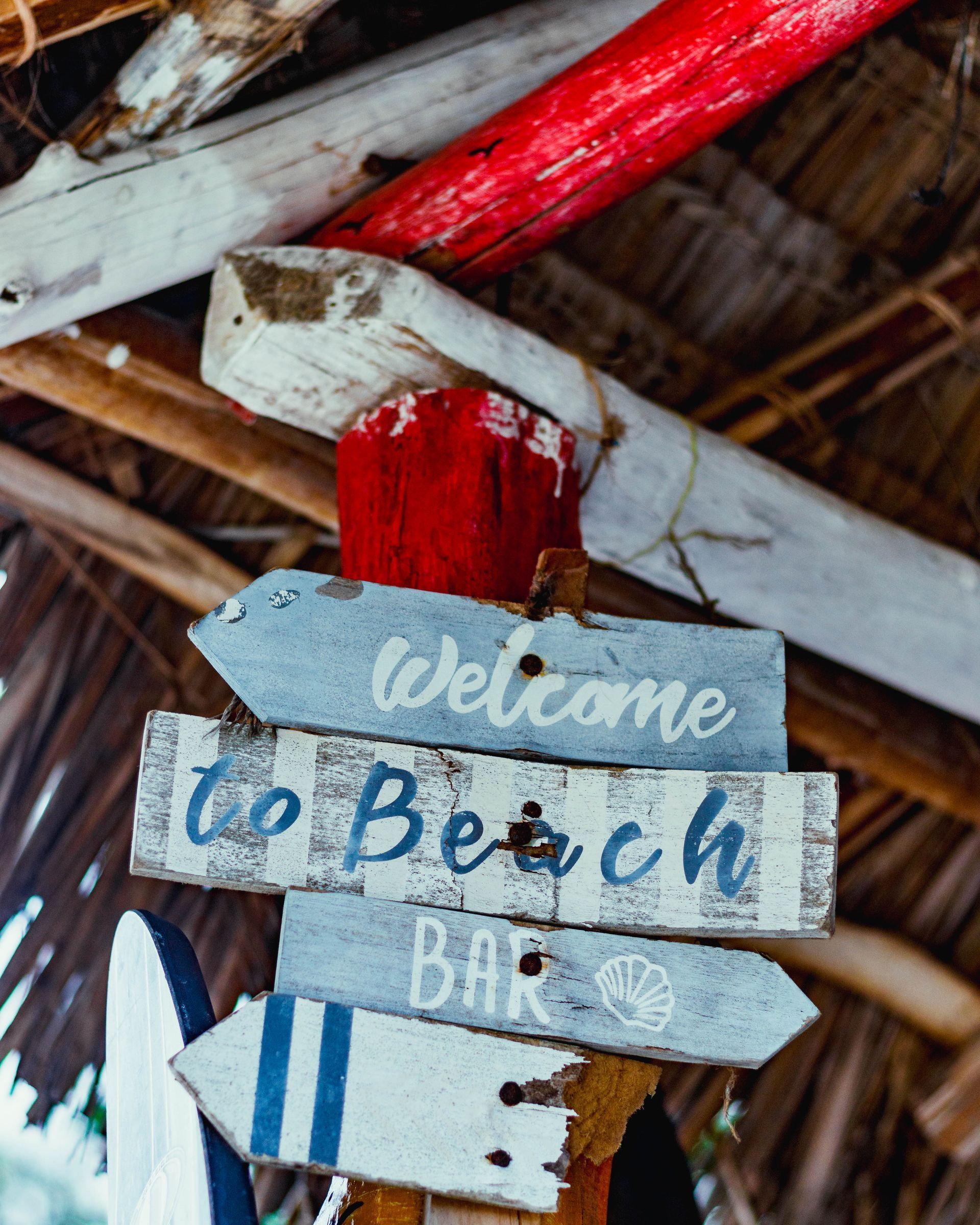 A wooden sign that says welcome to beach bar