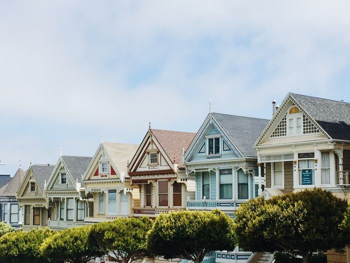 A row of houses with trees in front of them