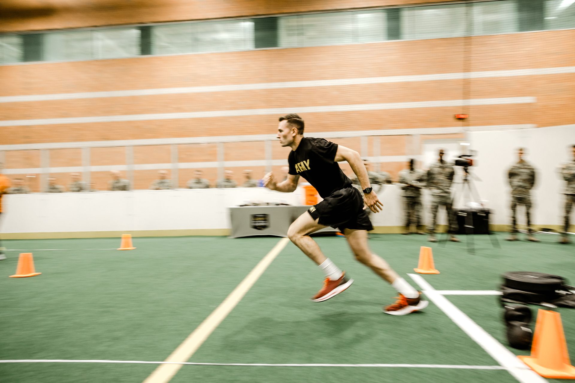 A man in a military uniform is running on a track