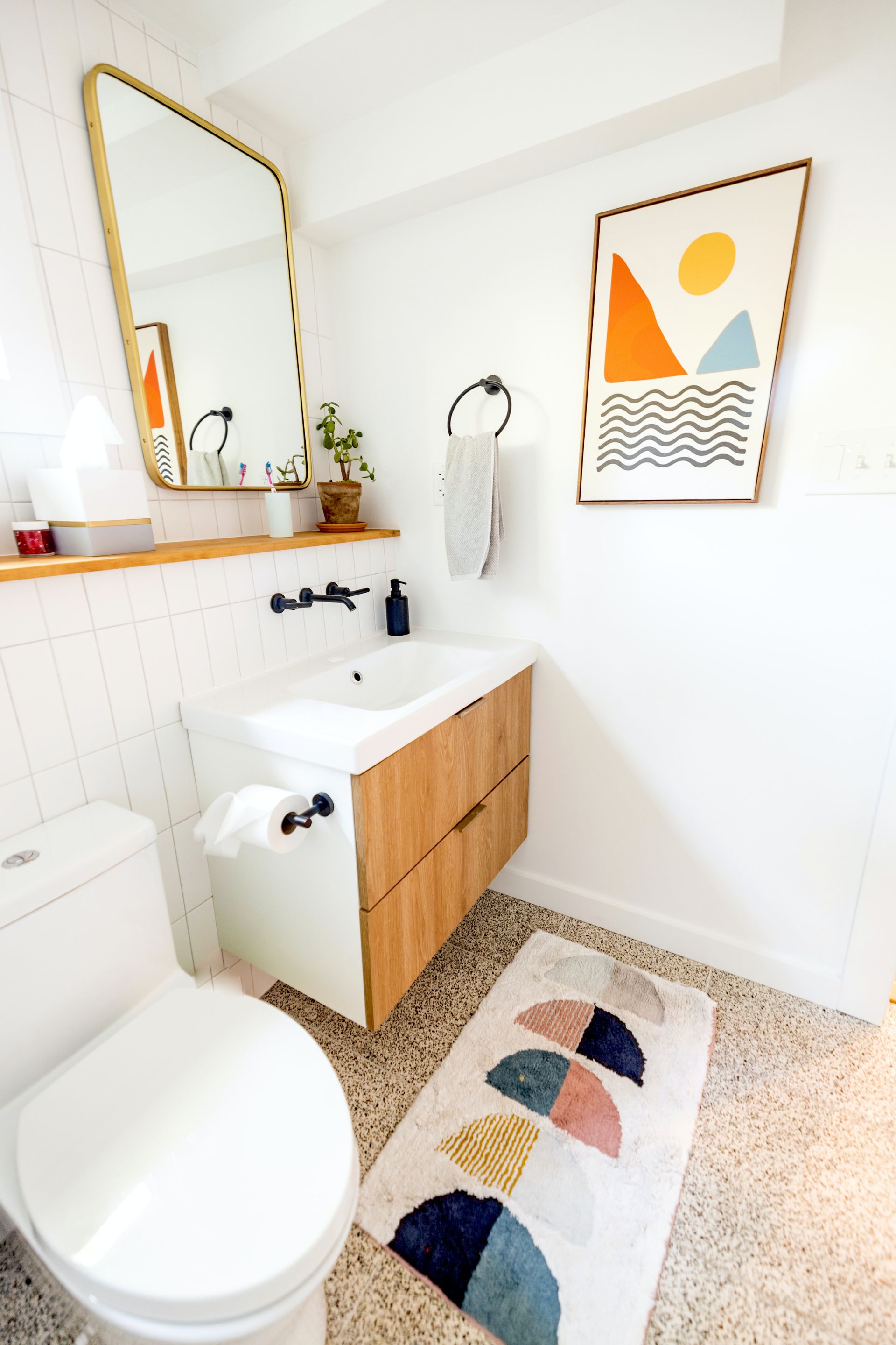 a bathroom makeover with a toilet, sink, mirror, and rug: The Ultimate Guide to a Bathroom Makeover 2024.