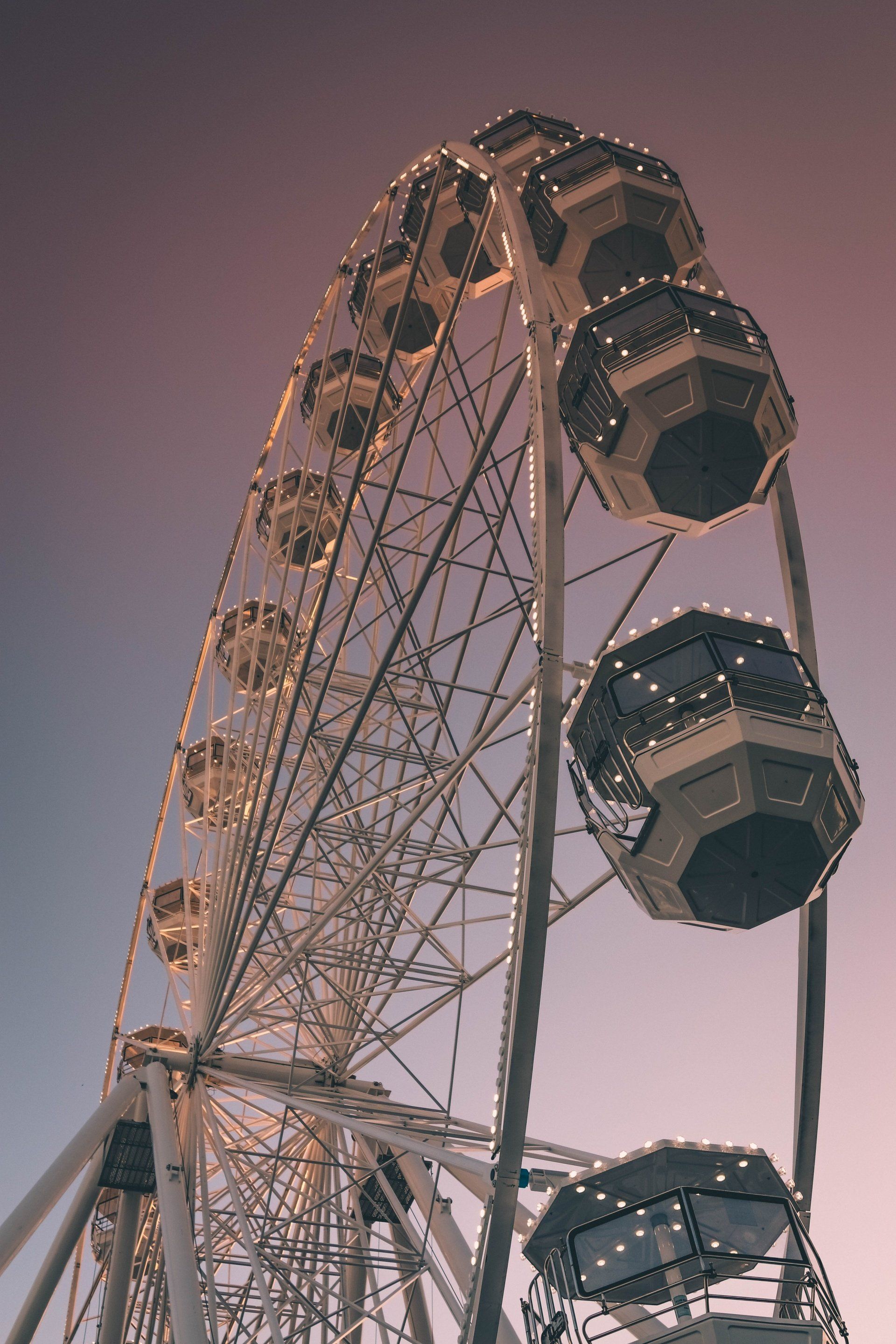 A ferris wheel with a pink sky in the background