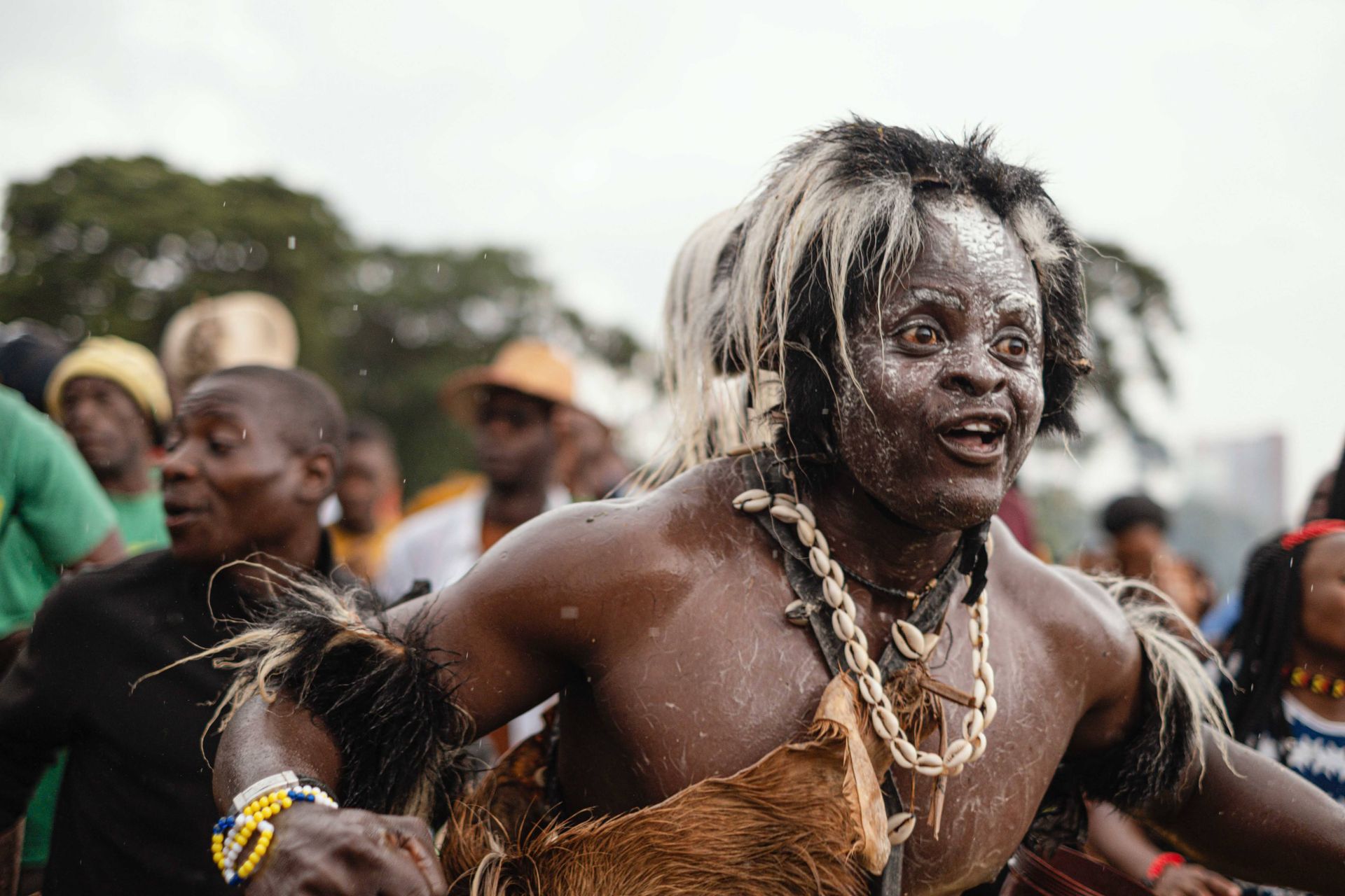 A man in a traditional costume is dancing in a crowd of people.