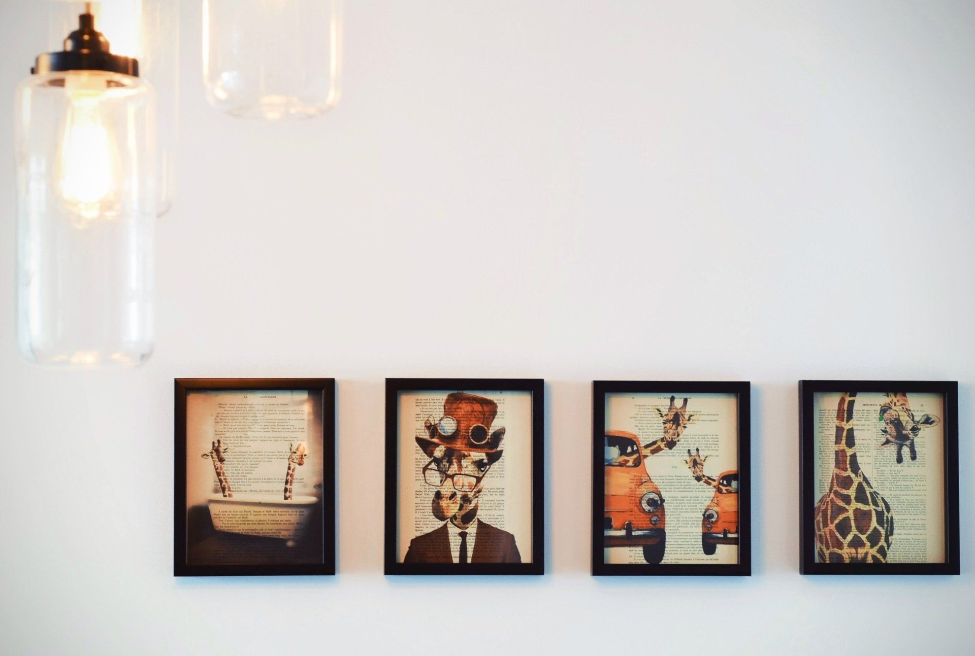 A row of four framed pictures on a white wall.