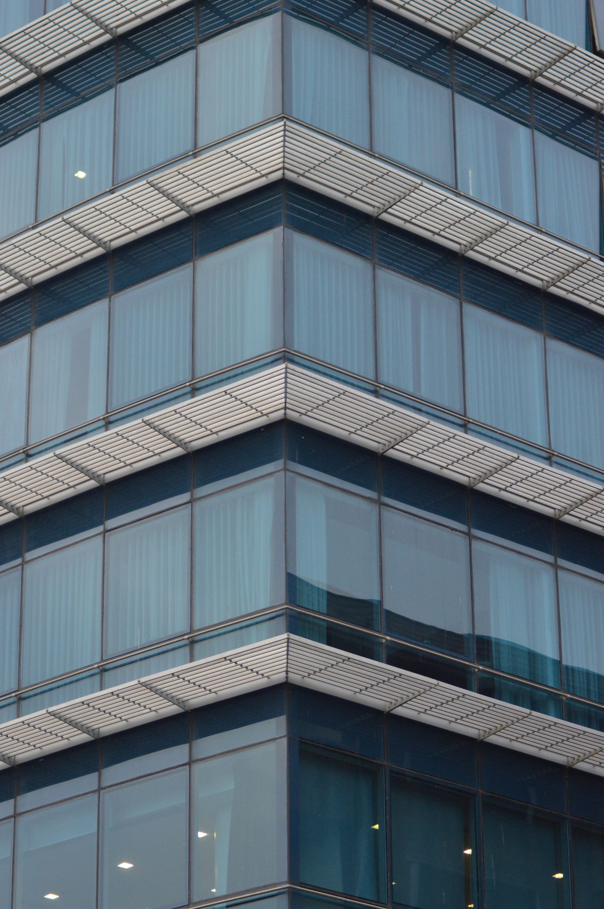 A close up of the corner of a tall building with a lot of windows.