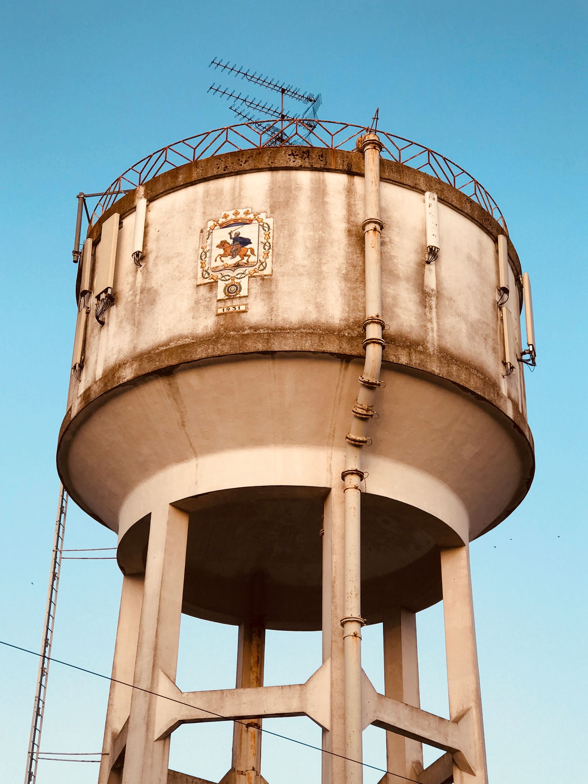 A water tower with a crest on top of it