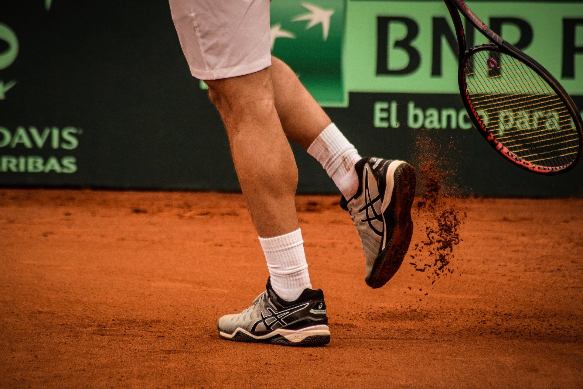 A man is holding a tennis racquet on a tennis court.