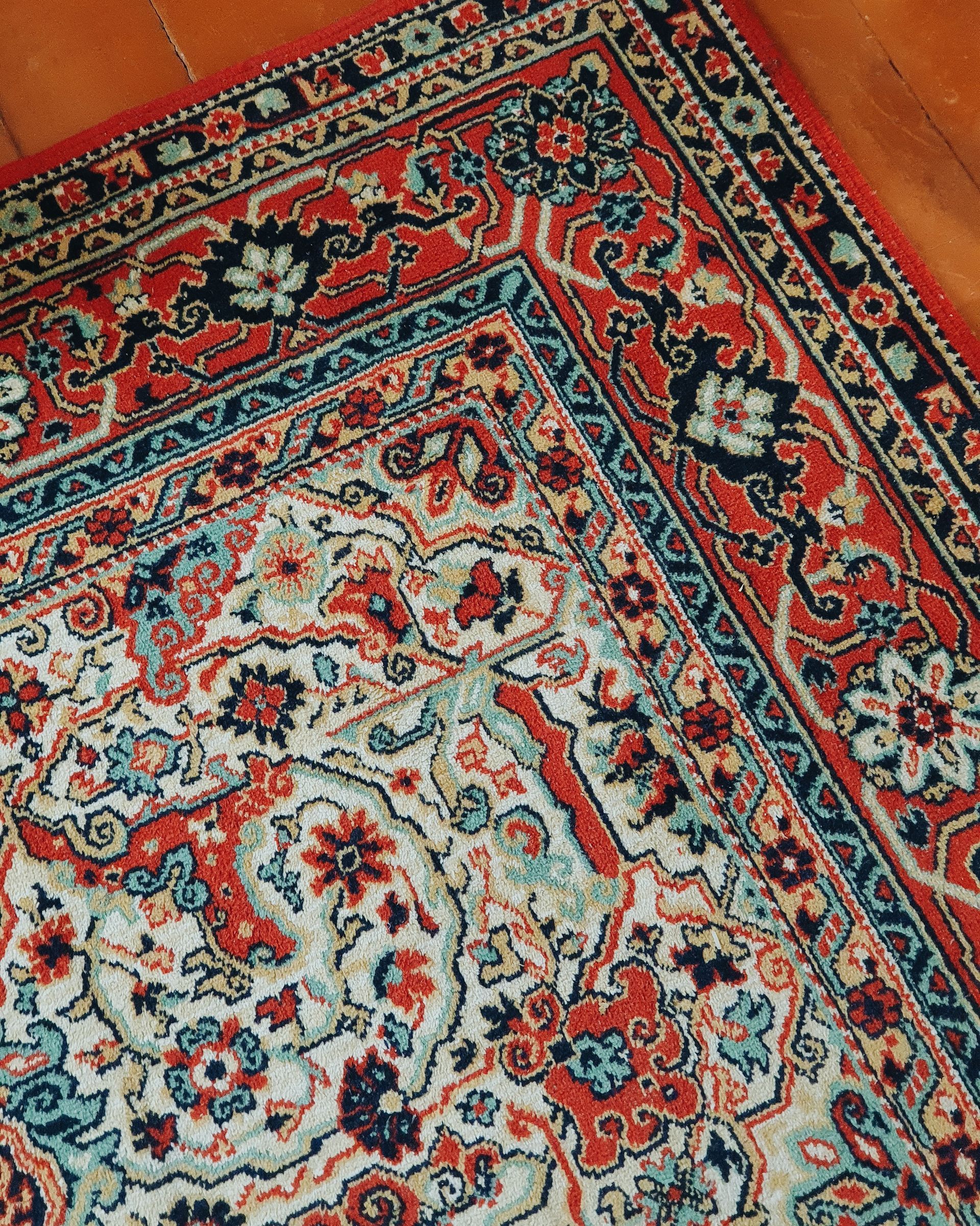 A close up of a rug on a wooden floor.
