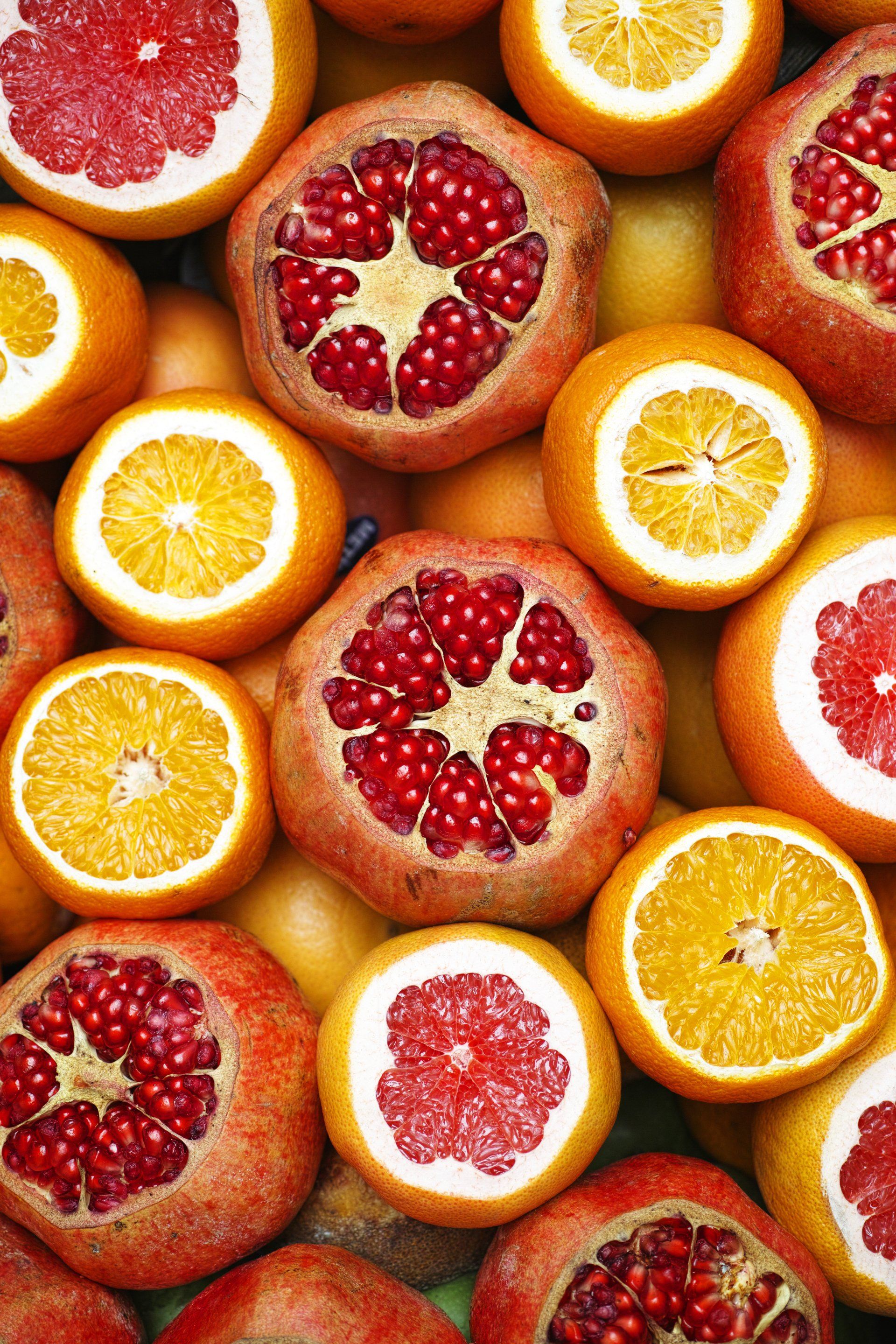 A bunch of different types of citrus fruits cut in half