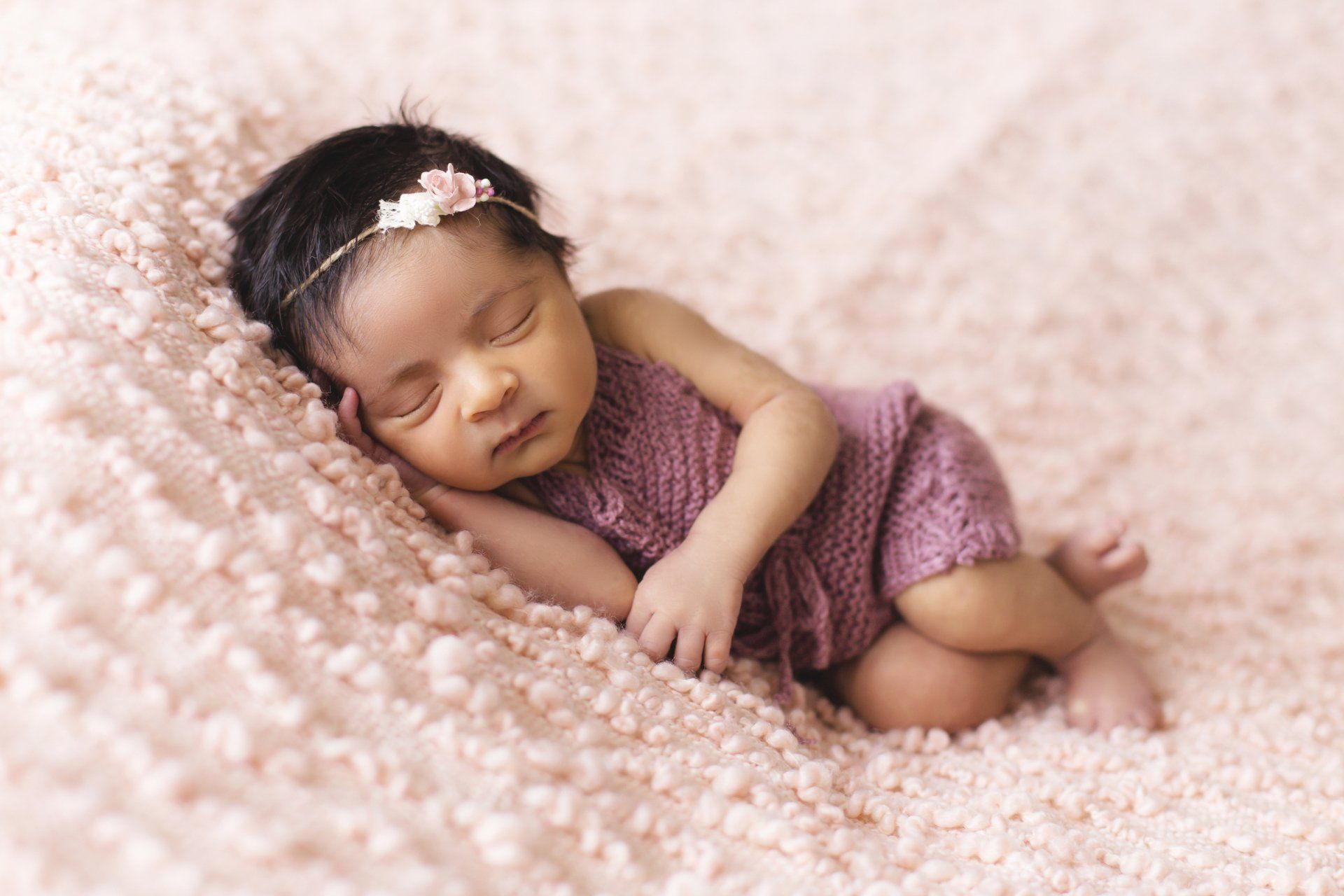 a newborn baby girl is sleeping on a pink blanket 