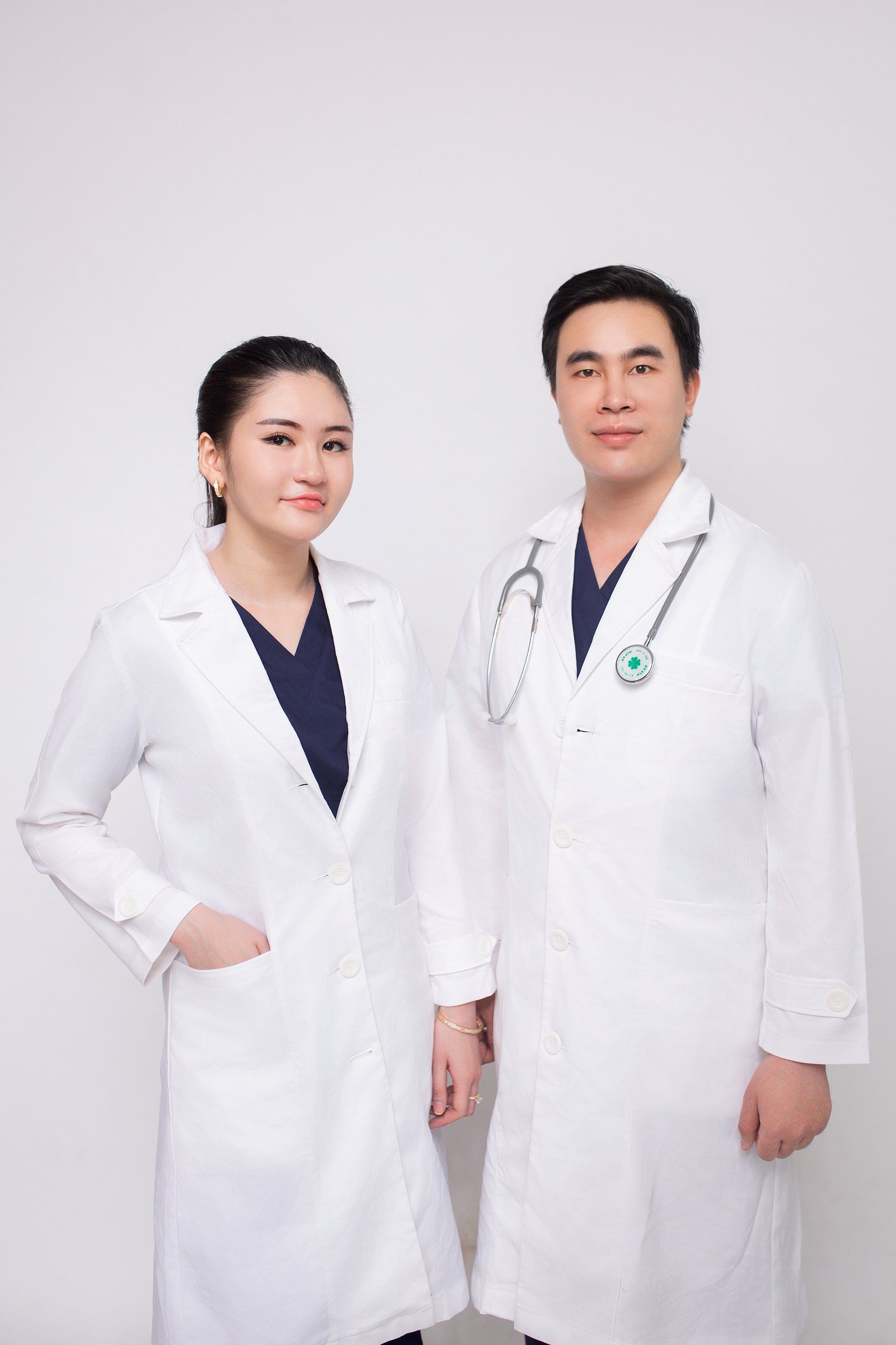 A man and a woman in white coats are standing next to each other.