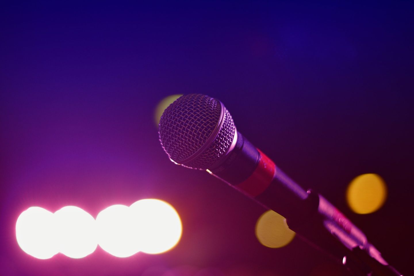 a microphone is sitting on a stand in front of purple lights .