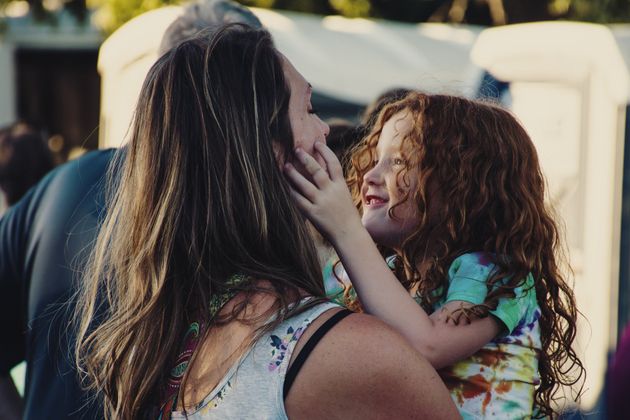 A woman is holding a little girl in her arms.