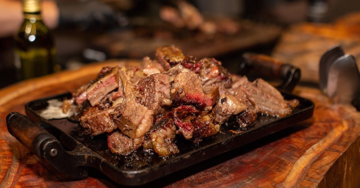 A tray of meat is sitting on top of a wooden table.