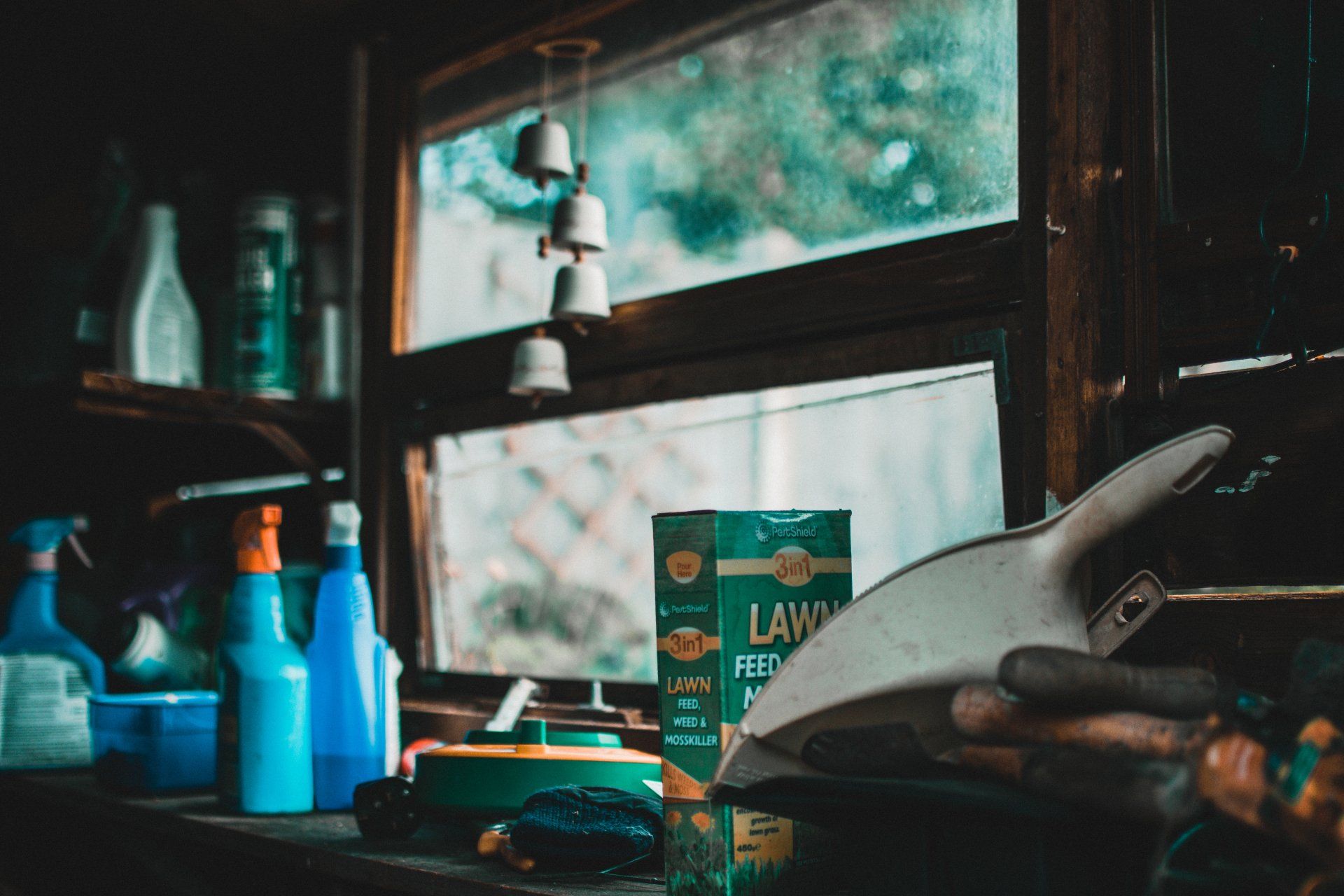 A box of lawn feed sits on a table in front of a window.