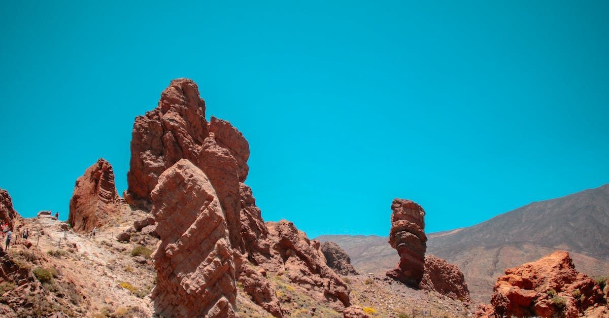 A group of rocks in the desert with a blue sky in the background.