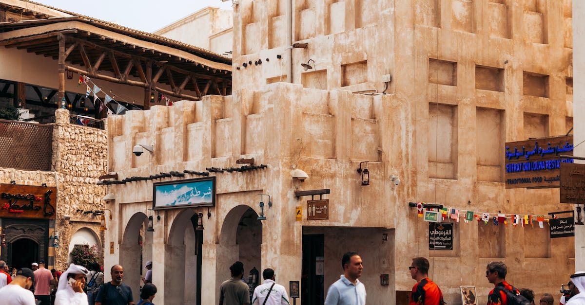 A group of people are walking down a street in front of a building.