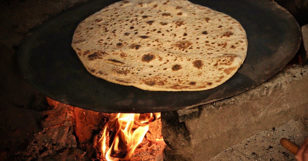 A tortilla is being cooked on a pan over a fire.