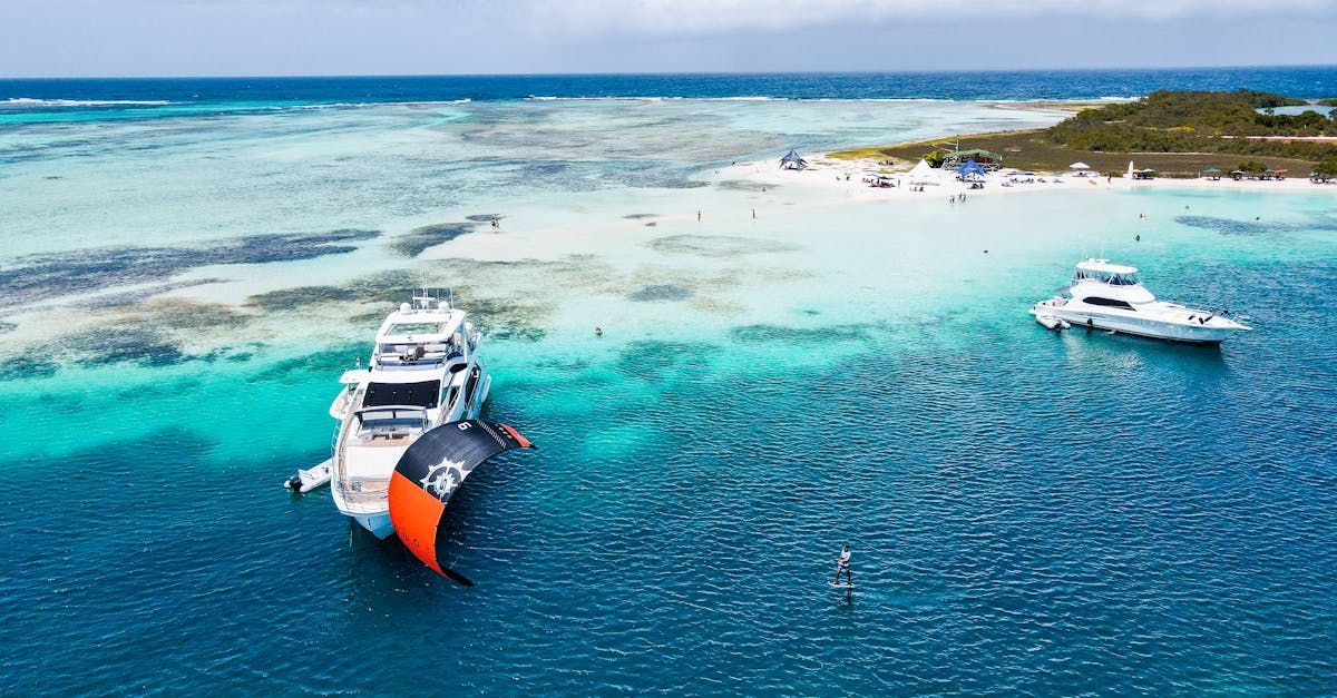 An aerial view of two boats in the ocean near a small island.