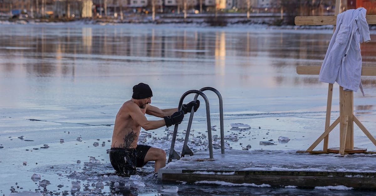 Man swimming in icy lake from dock