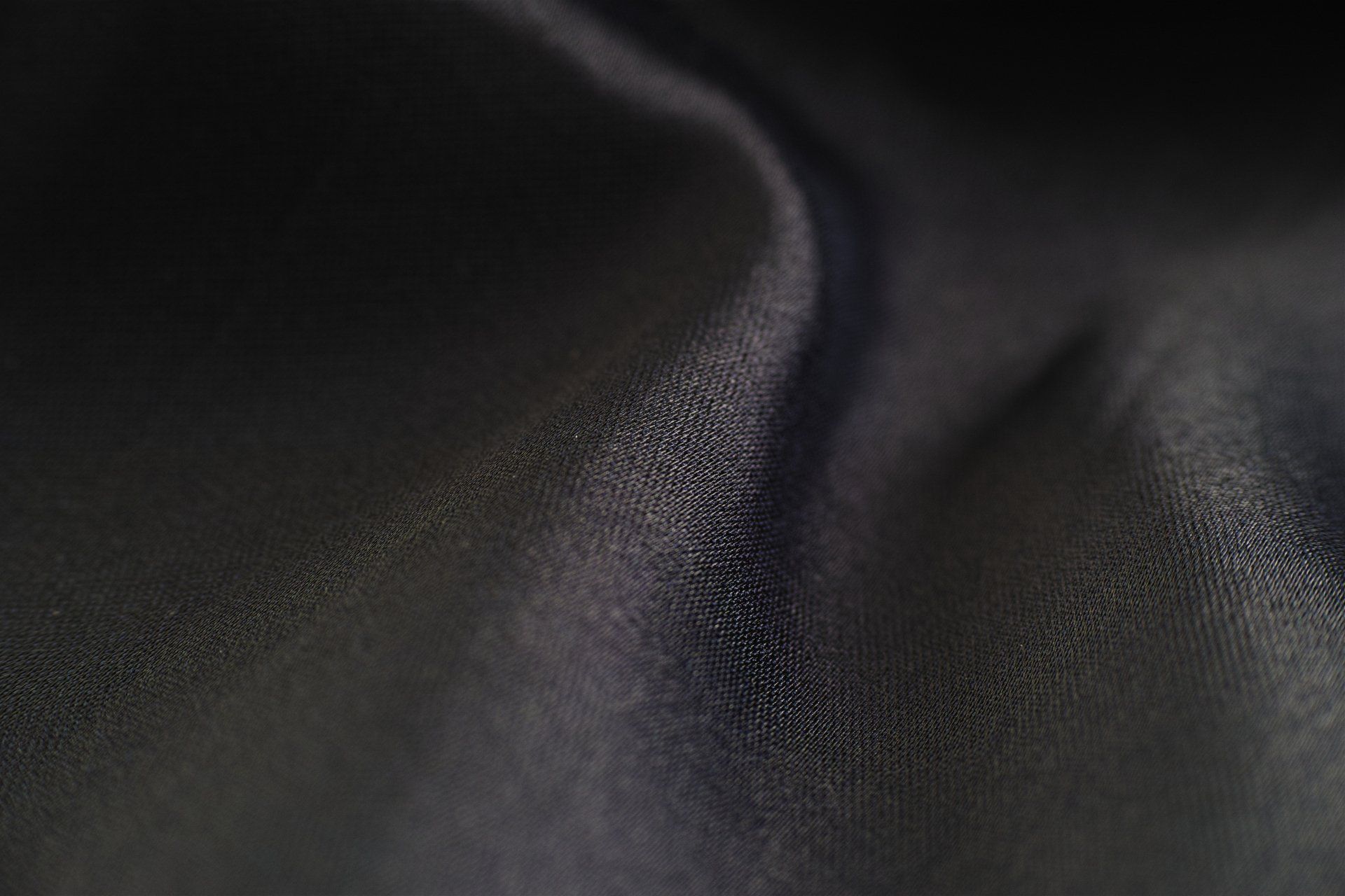 A close up of a black cloth with a swirl on it.