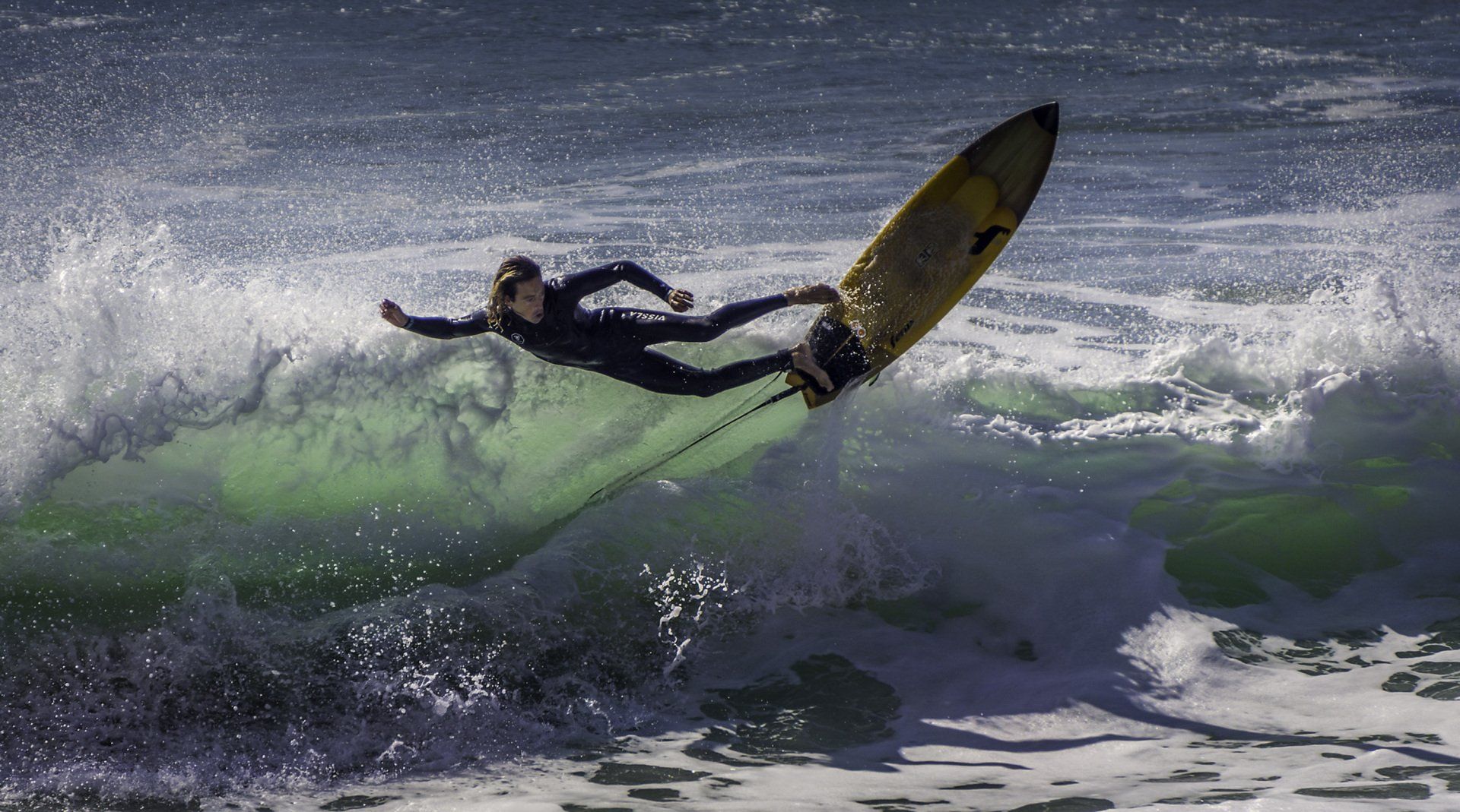 A man is riding a wave on a surfboard in the ocean.