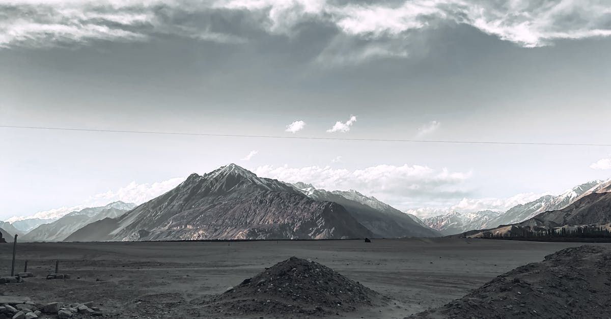 A black and white photo of a landscape with mountains in the background.
