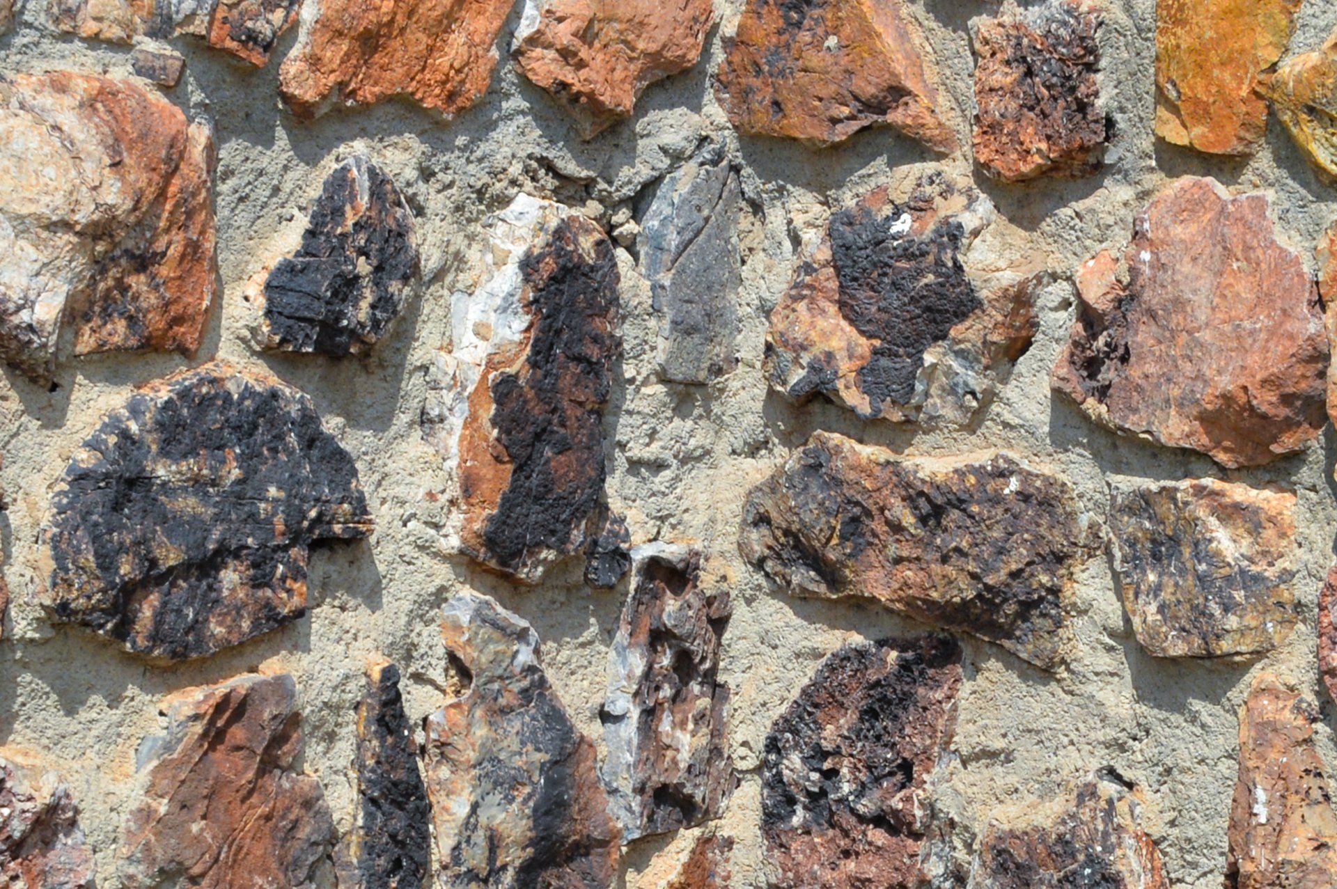 A close up of a stone wall with a lot of rocks. Old stone foundations that can be damp-proofed and repaired