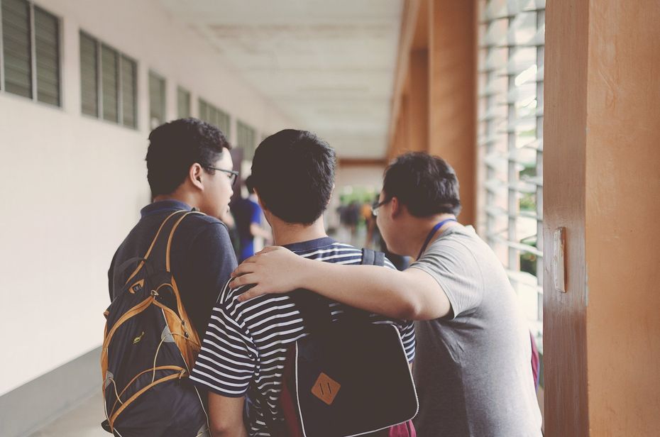 A group of young men are standing next to each other in a hallway.