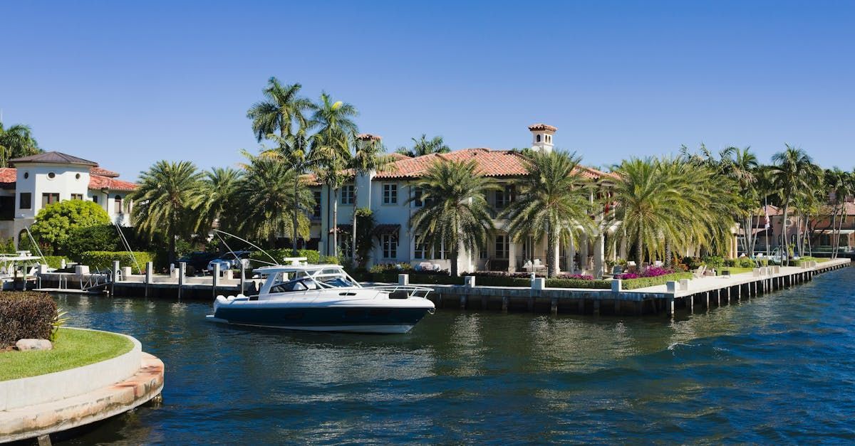 A boat is docked in a canal next to a house.