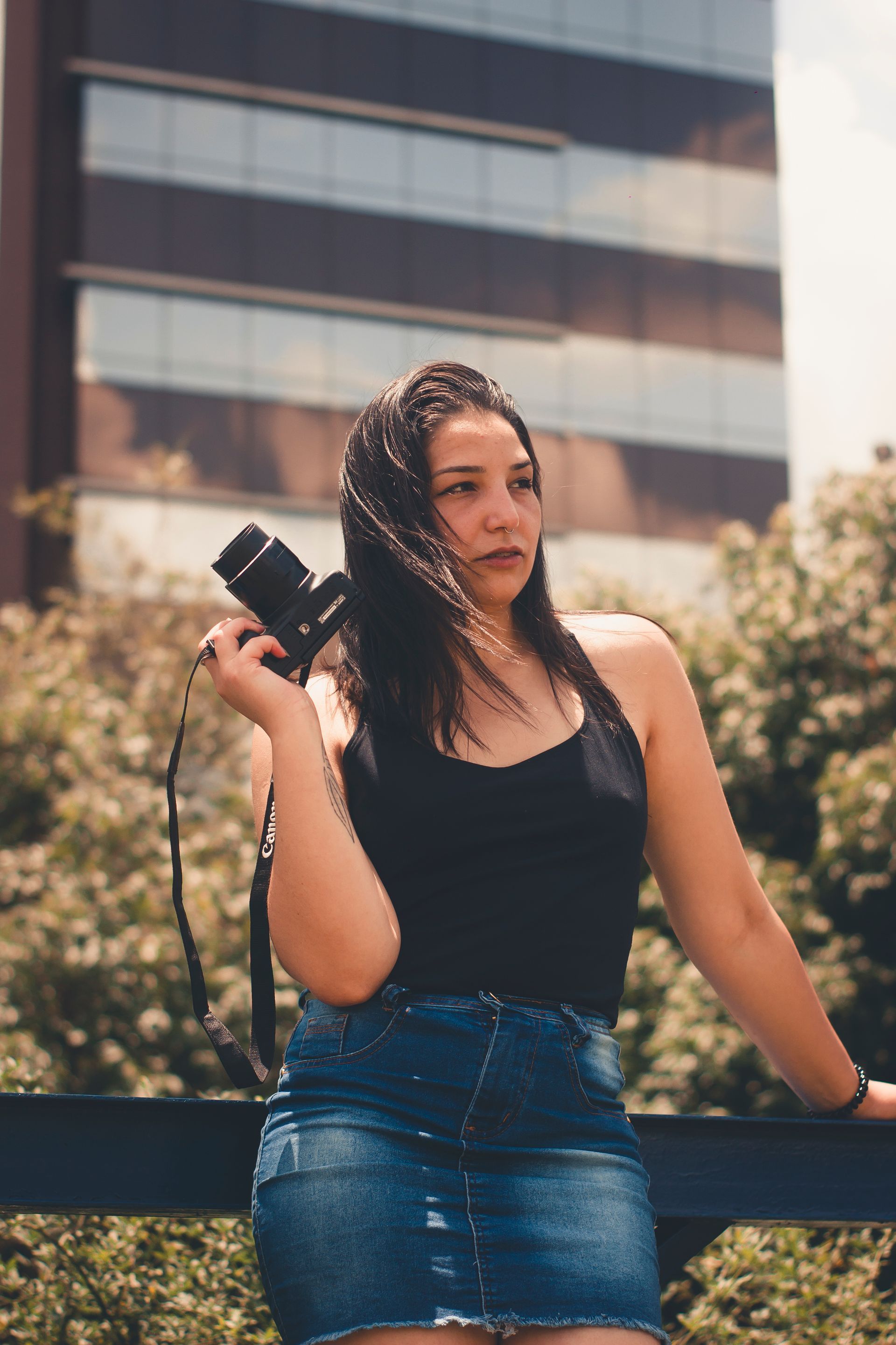 Young Latin woman in the city holding a camera.