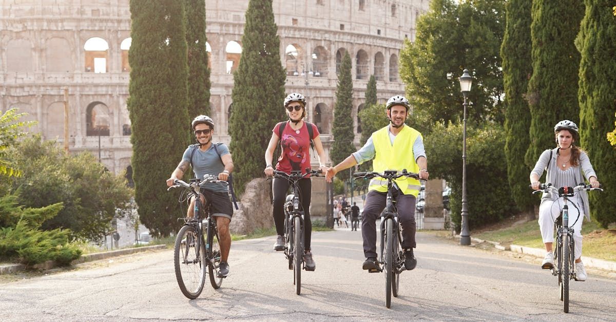 A group of people are riding bicycles down a street in front of the colosseum.