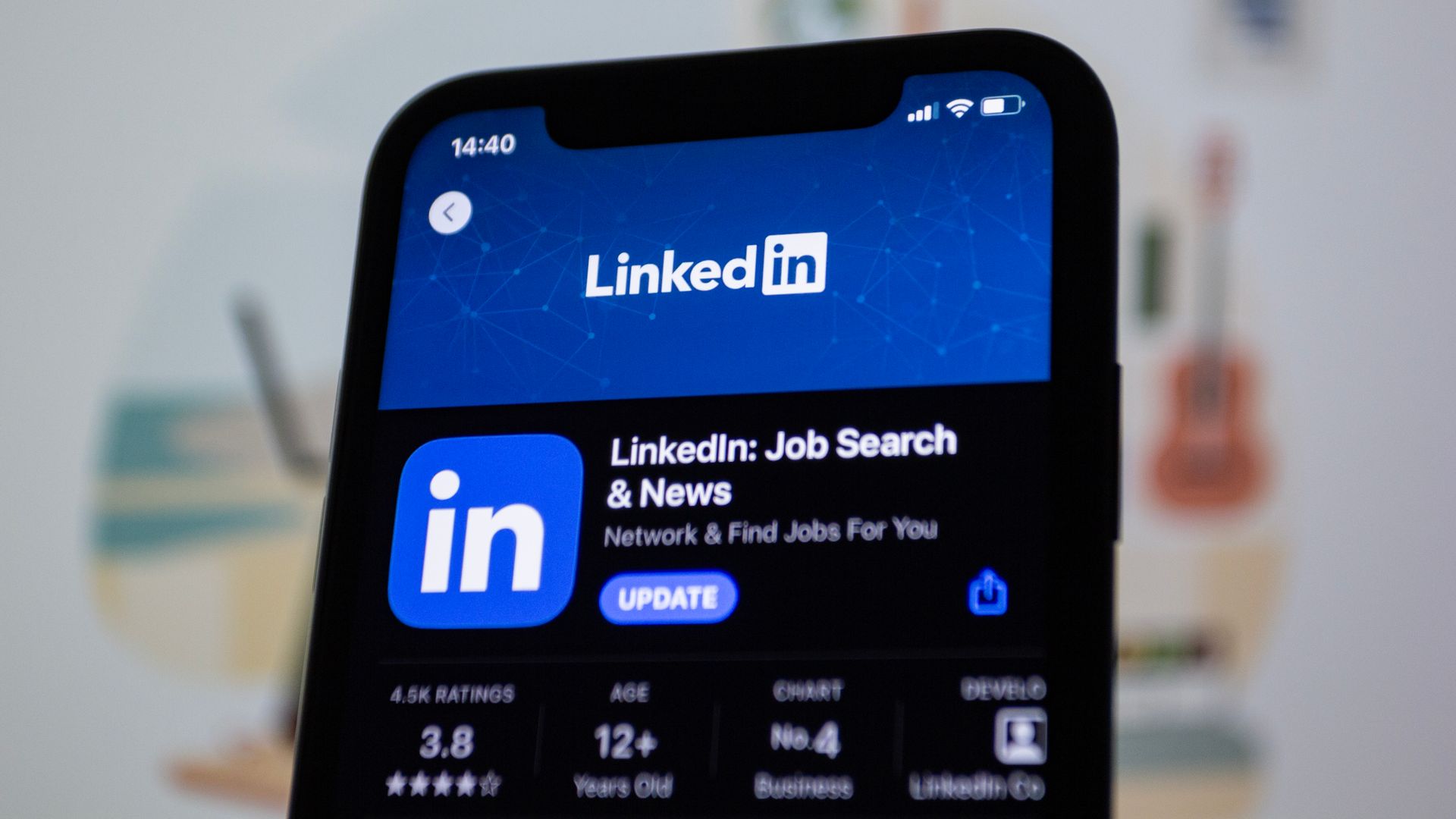 A close up of a cell phone displaying the linkedin job search and news app.