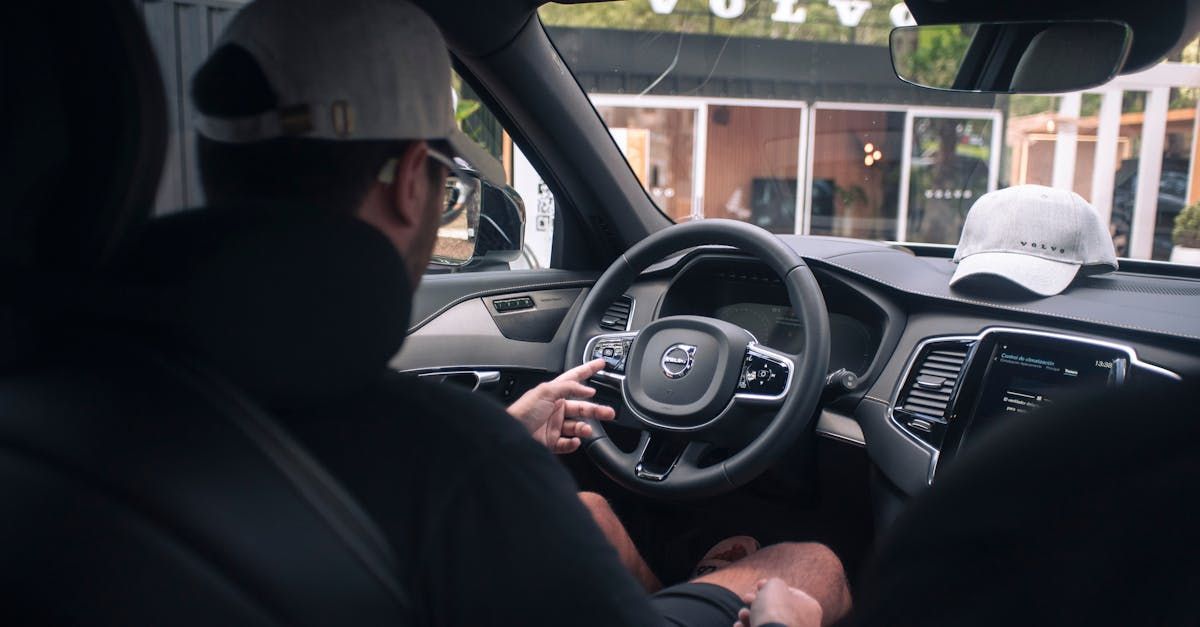 Un hombre está sentado en el asiento del conductor de un Volvo.