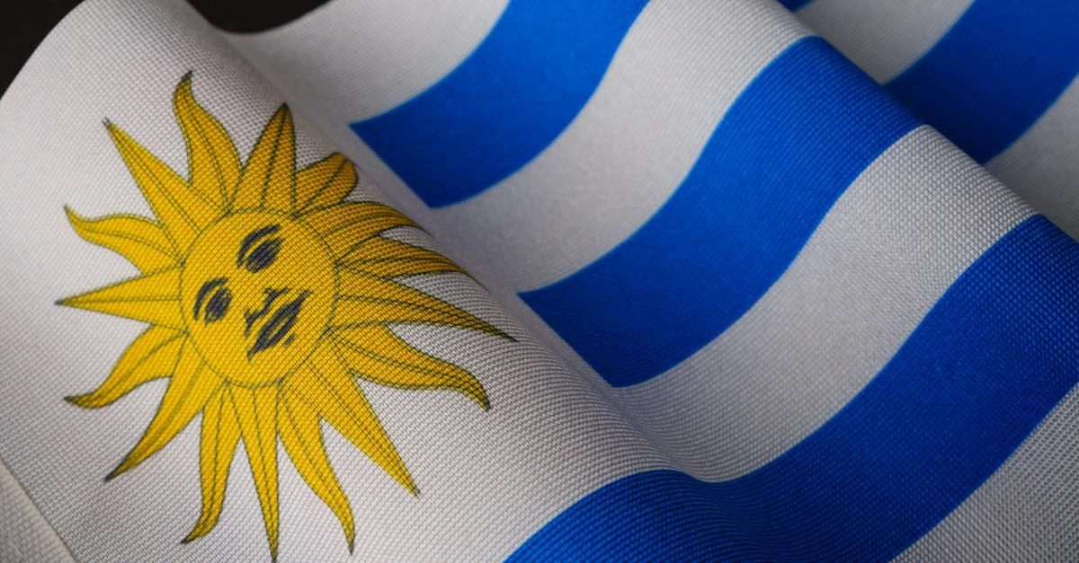 A close up of a blue and white striped flag with a sun on it.