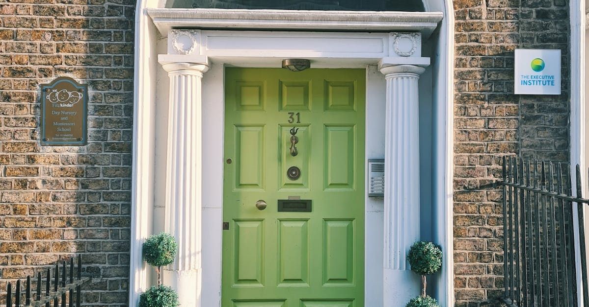 una porta verde si trova sulla facciata di un edificio in mattoni.