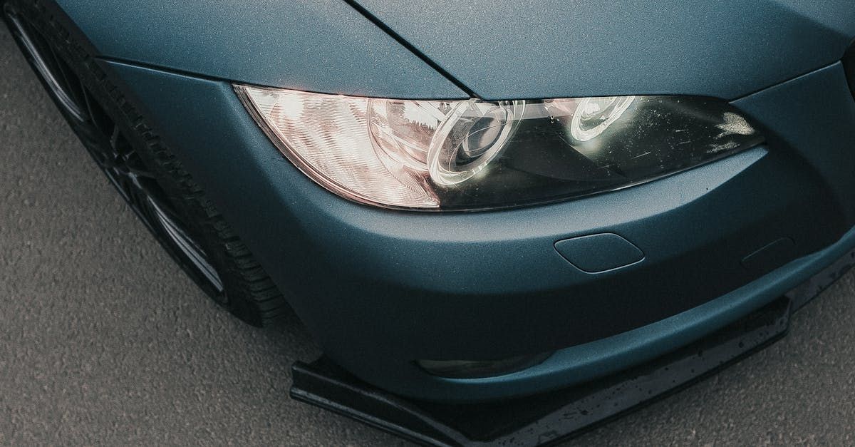 a close up of a blue car 's headlight on a road .