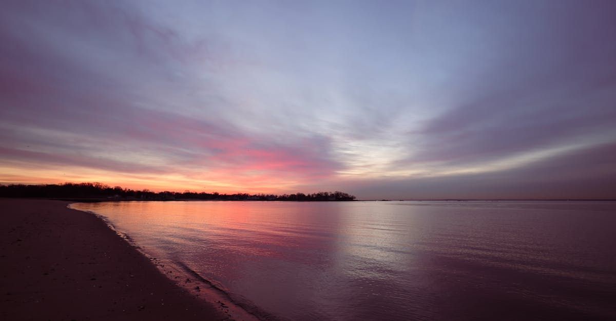 A sunset over a body of water with a purple sky
