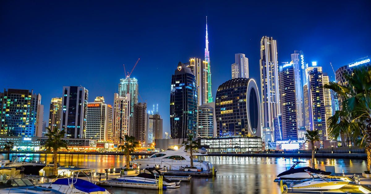 A city skyline at night with boats in the foreground